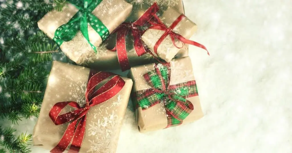 Presents wrapped in kraft wrapping paper and red and green ribbon - Best Christmas gifts for couples