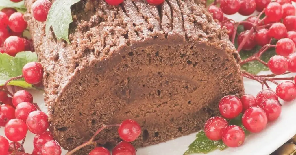 Yule Log Cake Decorated with festive berries and holly - Open for Christmas
