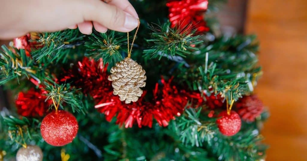 Red Tinsel and Baubles on a Christmas Tree - How to Decorate and Put Tinsel On a Christmas Tree - Open for Christmas